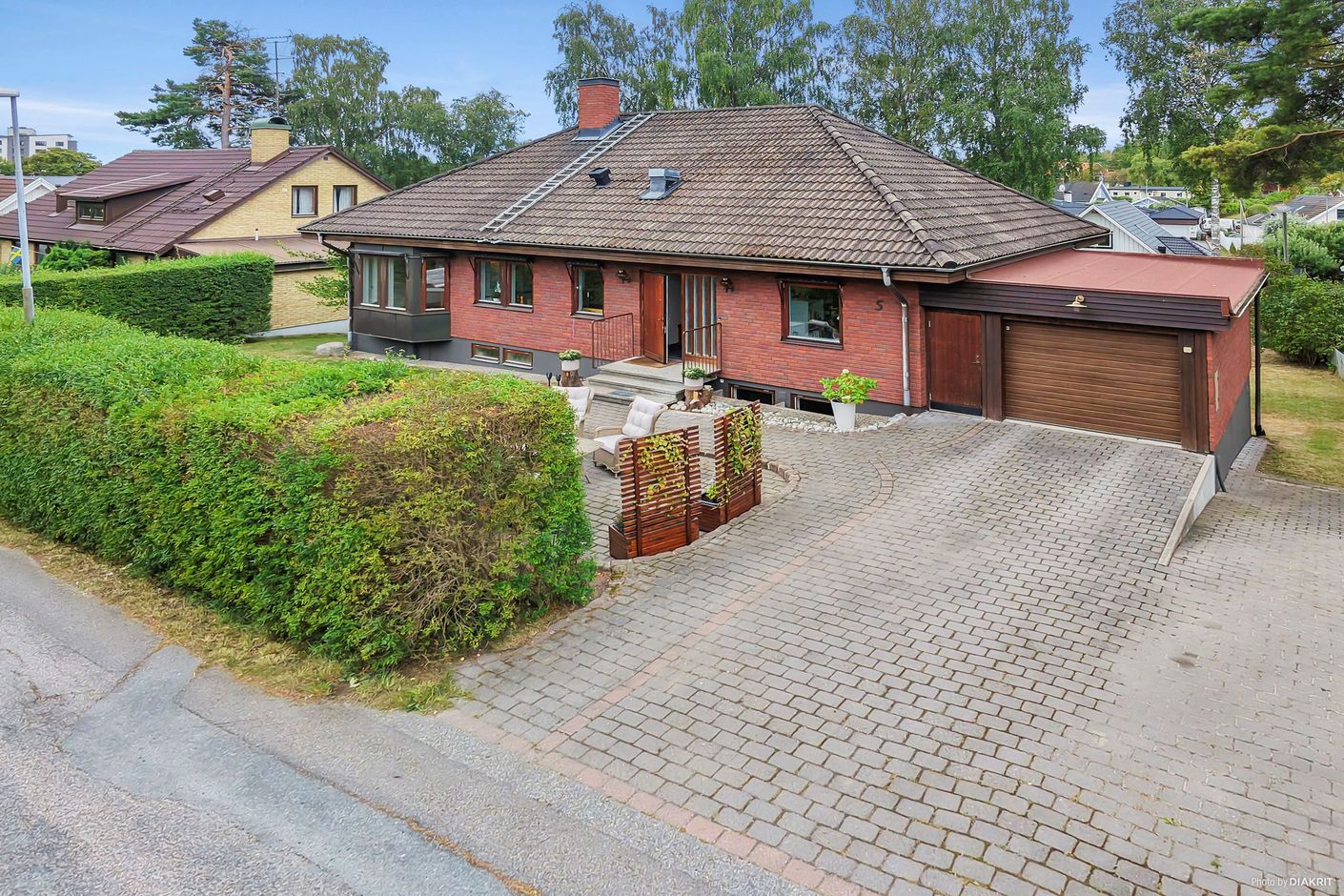 Fasadbild från entrésidan, med bilplatser och garage