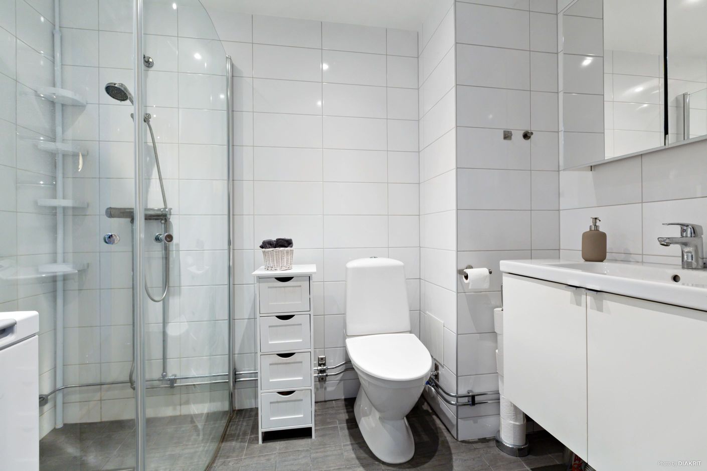 Renoverat och helkaklat WC-/duschrum med tvättmaskin
