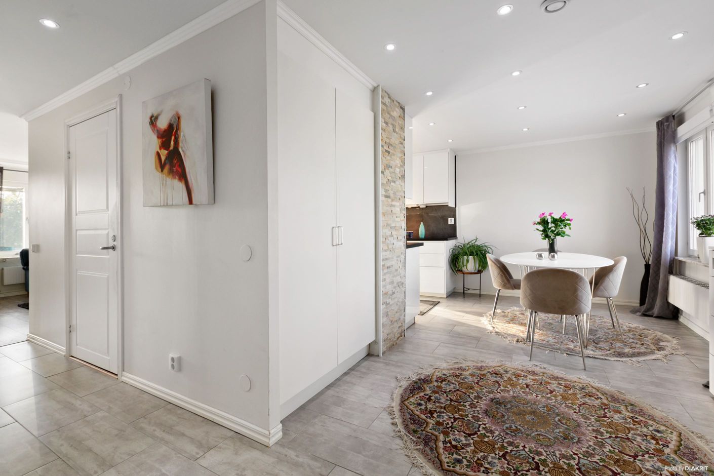Hall med stor matplats i öppen planlösning med köket