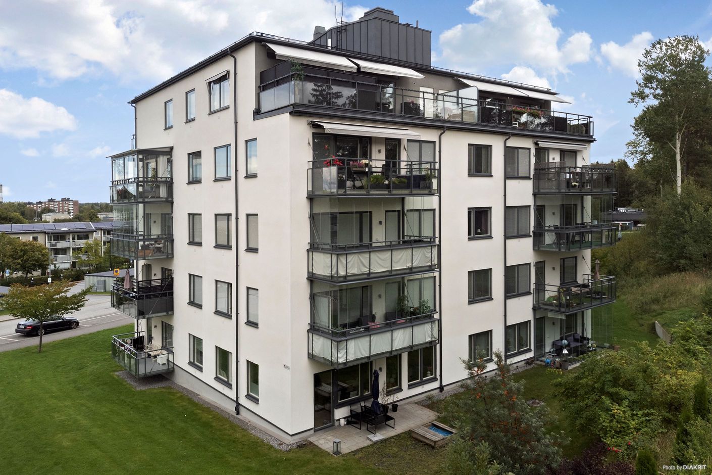 Fasadbild från baksidan med stor terrass, högst upp i huset, i söderläge