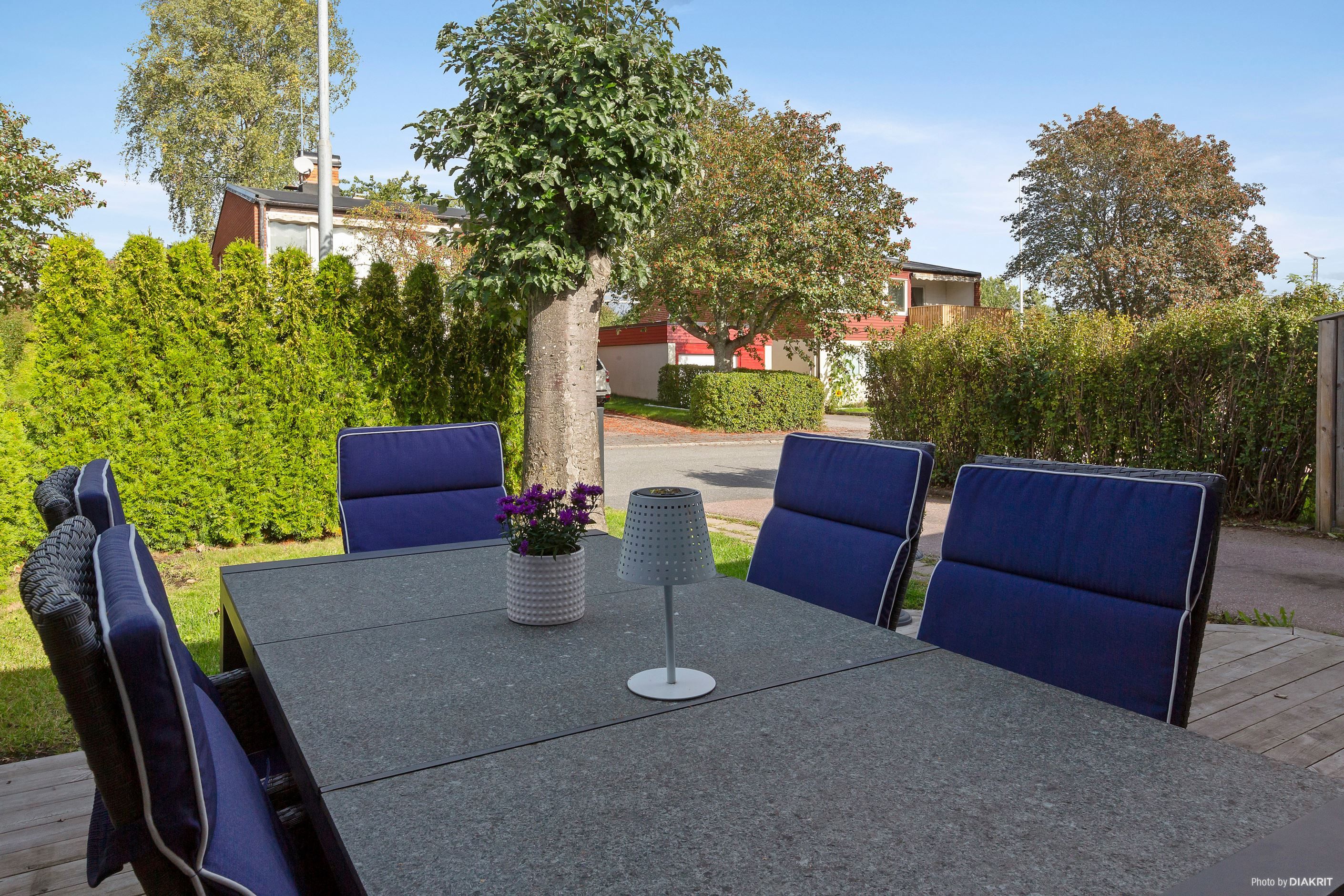 Trädäcksförsedd altan/uteplats på entrésidan i anslutning till köket
