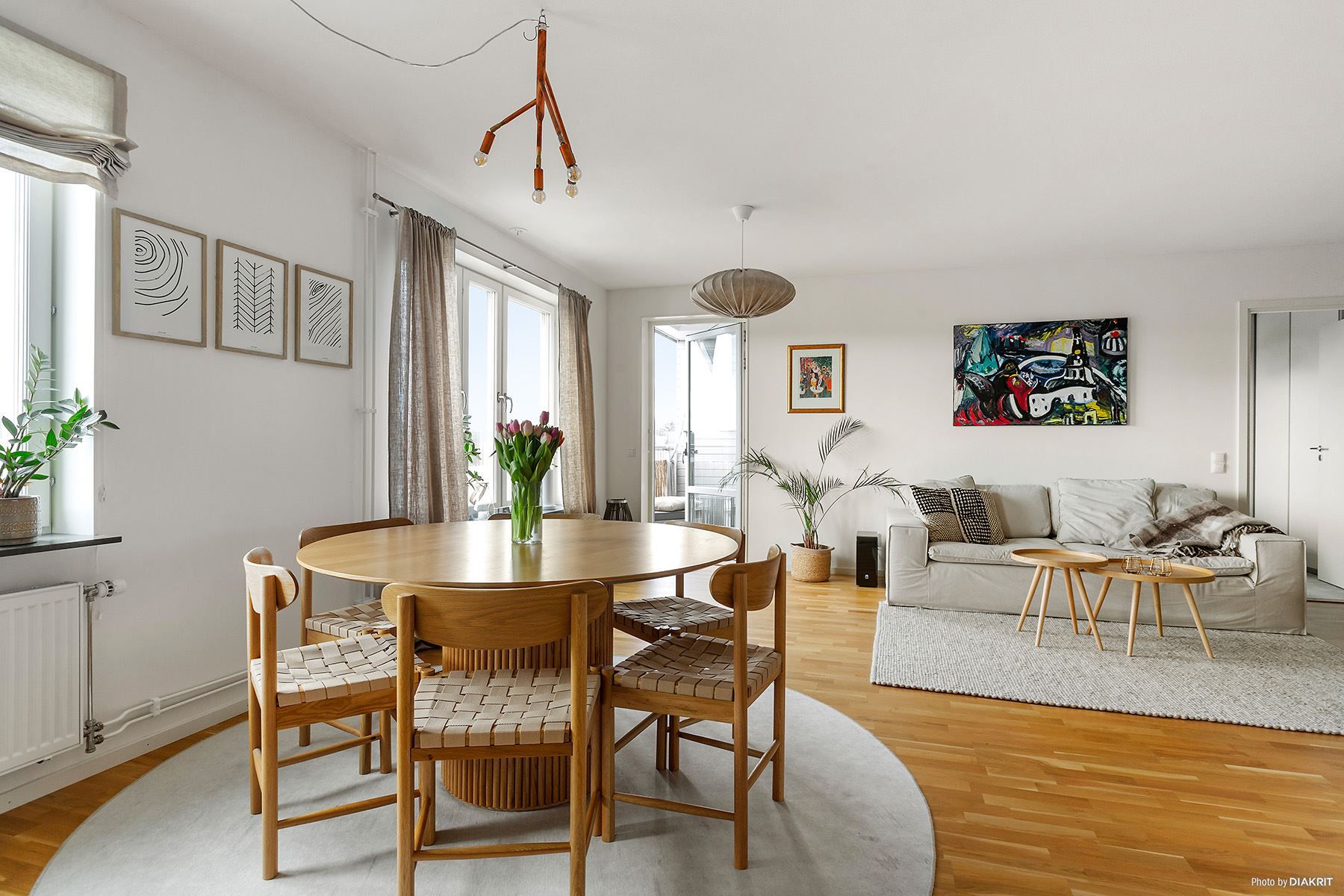 Matplats i köket i öppen planlösning med vardagsrummet och med utgång till balkong