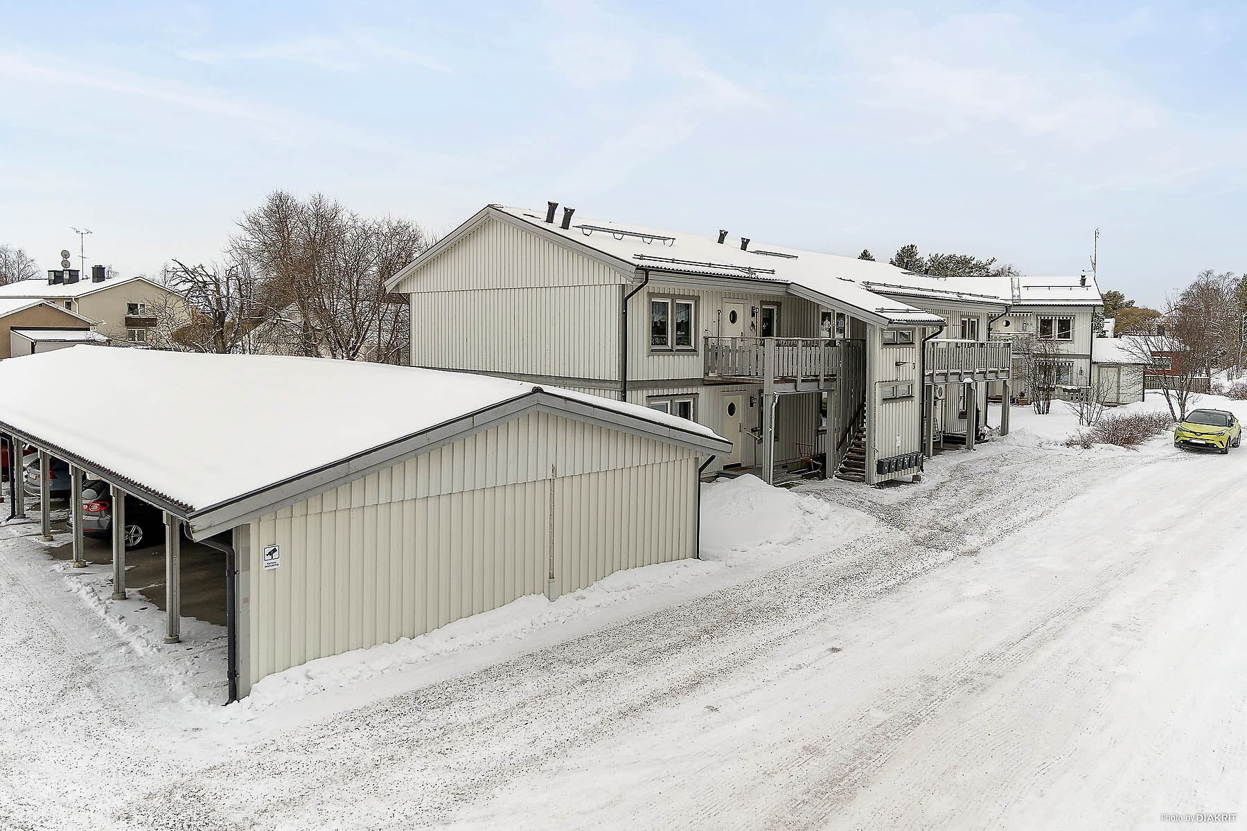 Värdshusgatan med carport och uteplats vid entrén