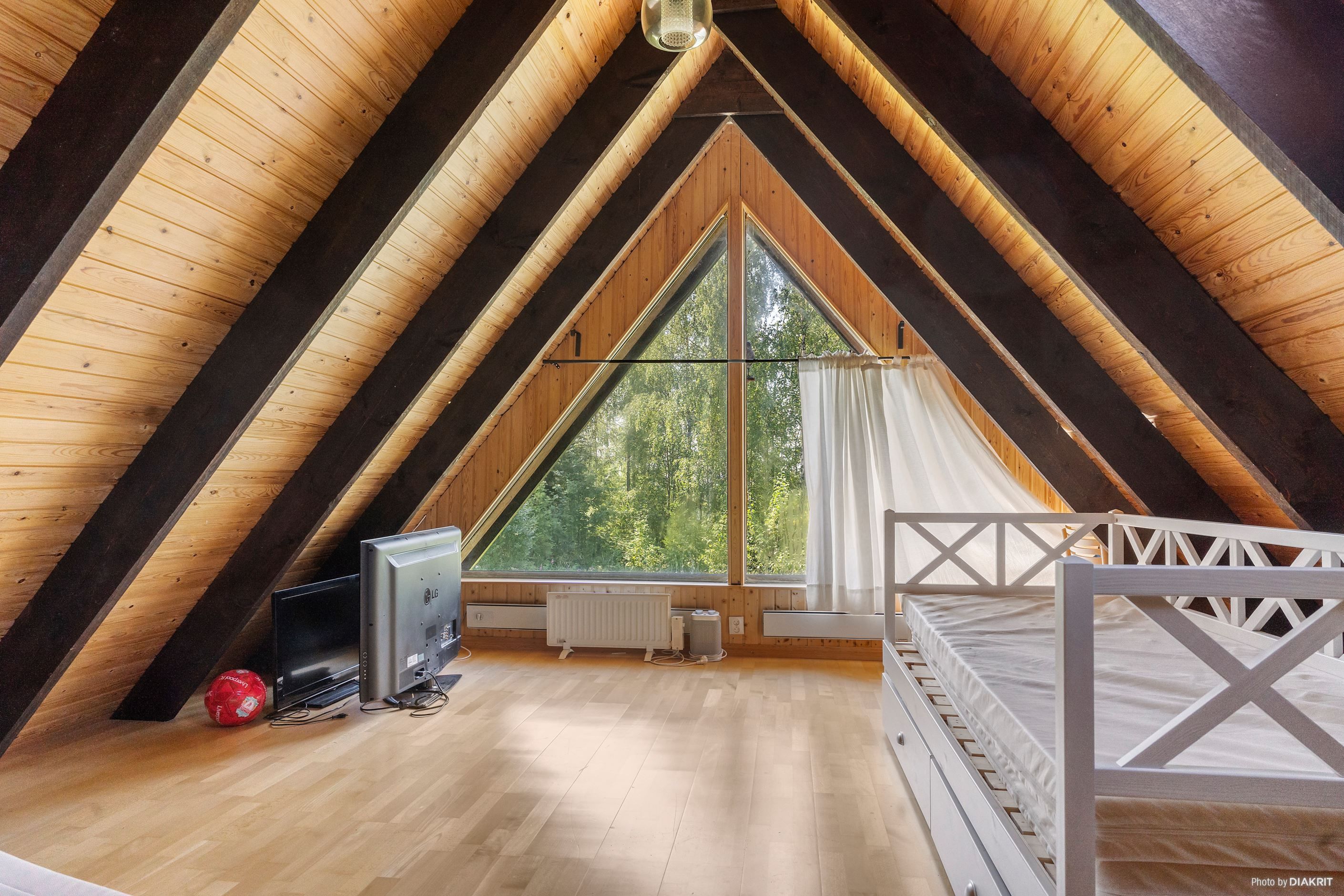 Allrum/sovrum på loftet med stora fönster
