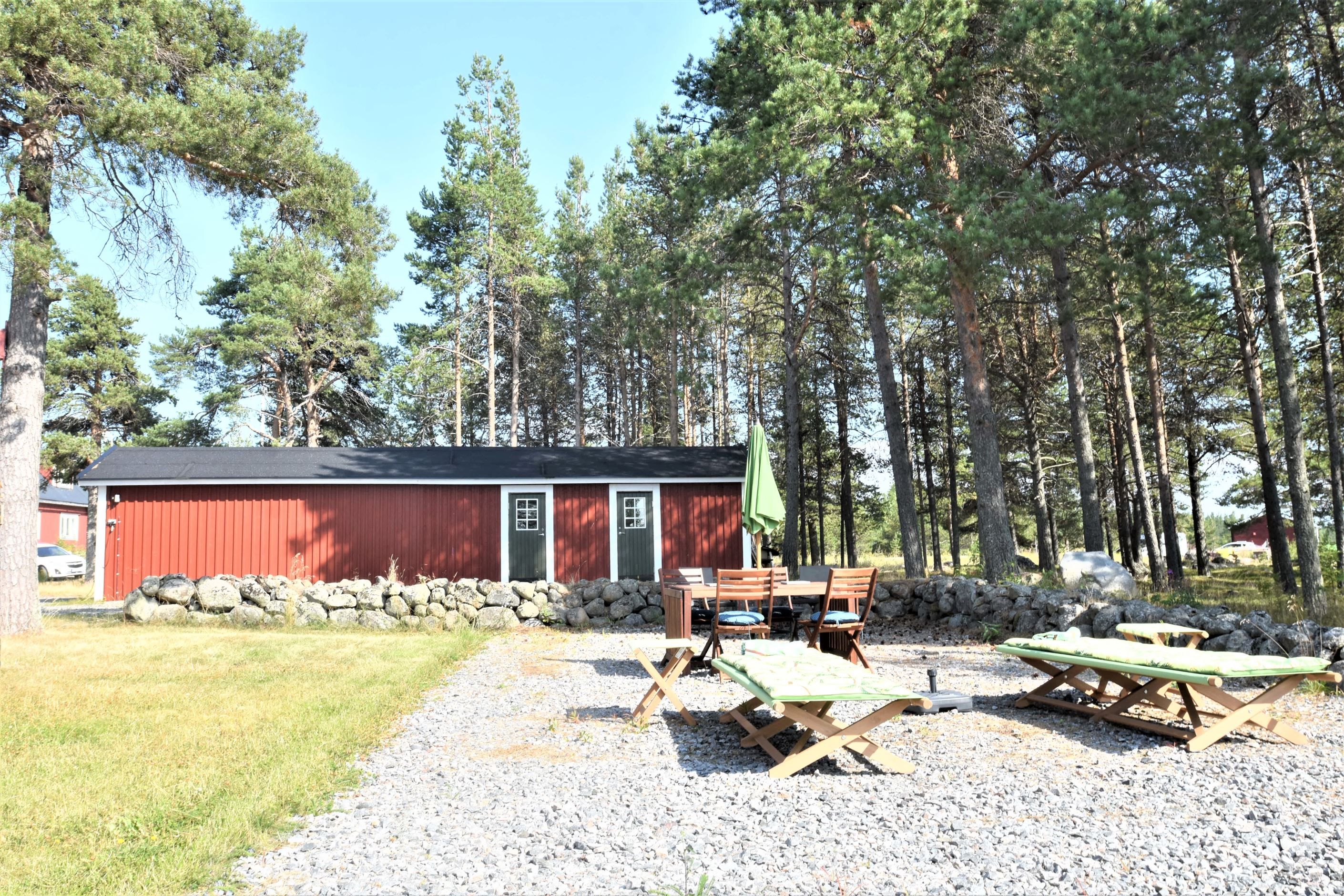 Garagelänga med förråd och grusad uteplats.