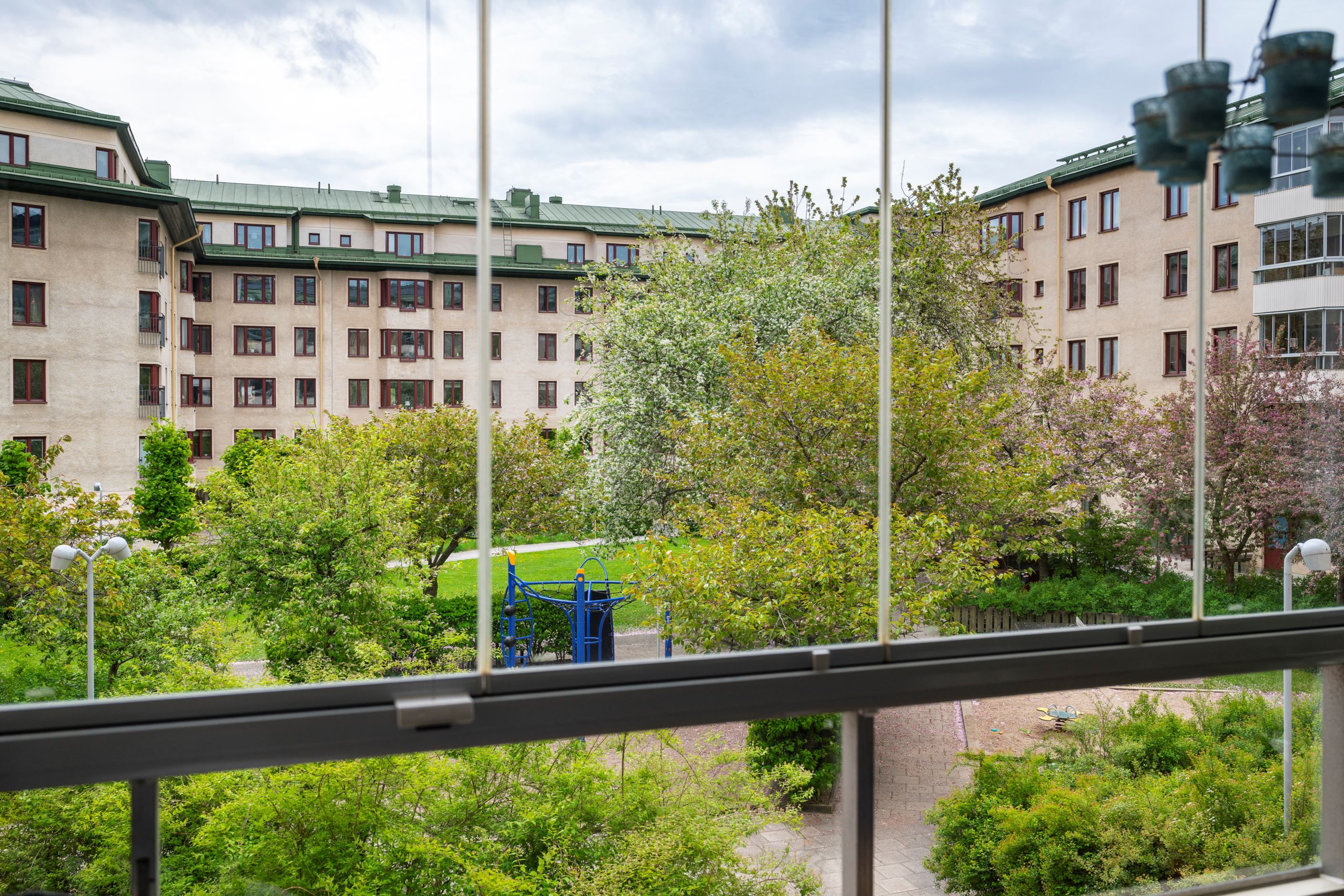Balkong mot grönskande gård