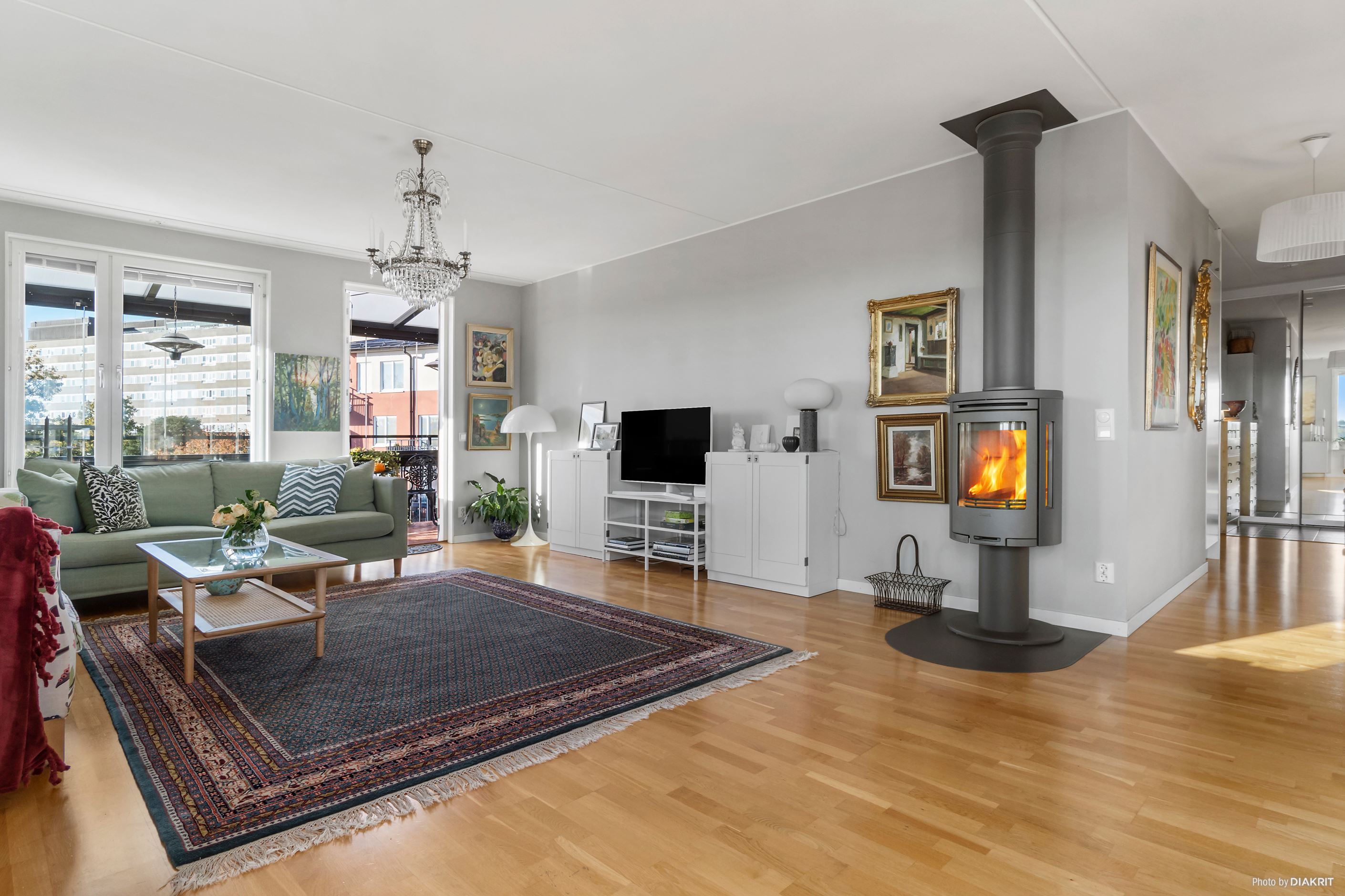 Vardagsrum med braskamin och utgång till stor inglasad balkong