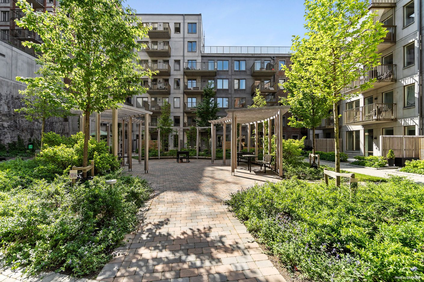 Fin innergård med pergola, sittplatser och grill