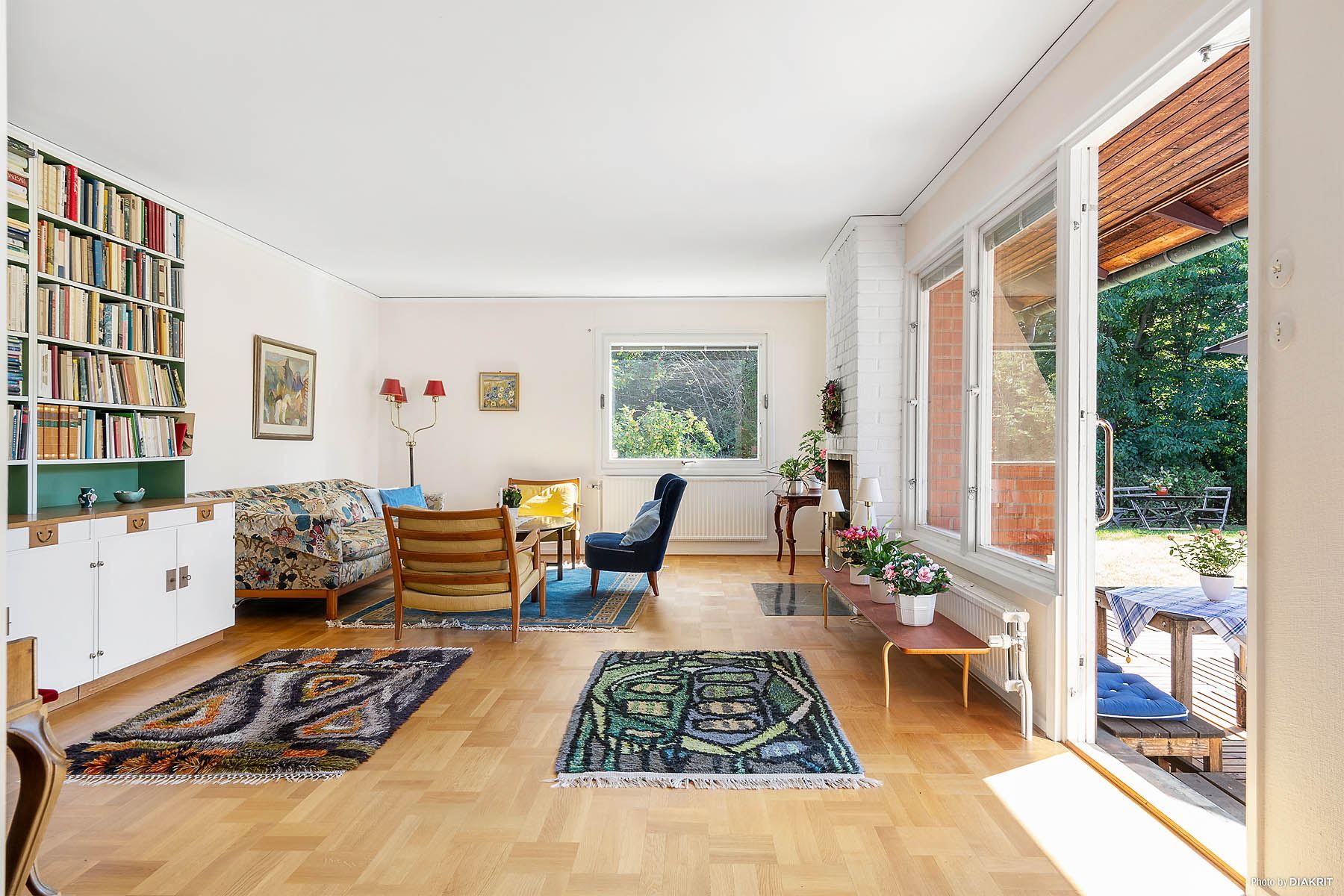 Vardagsrum med öppen spis och utgång till trädgården
