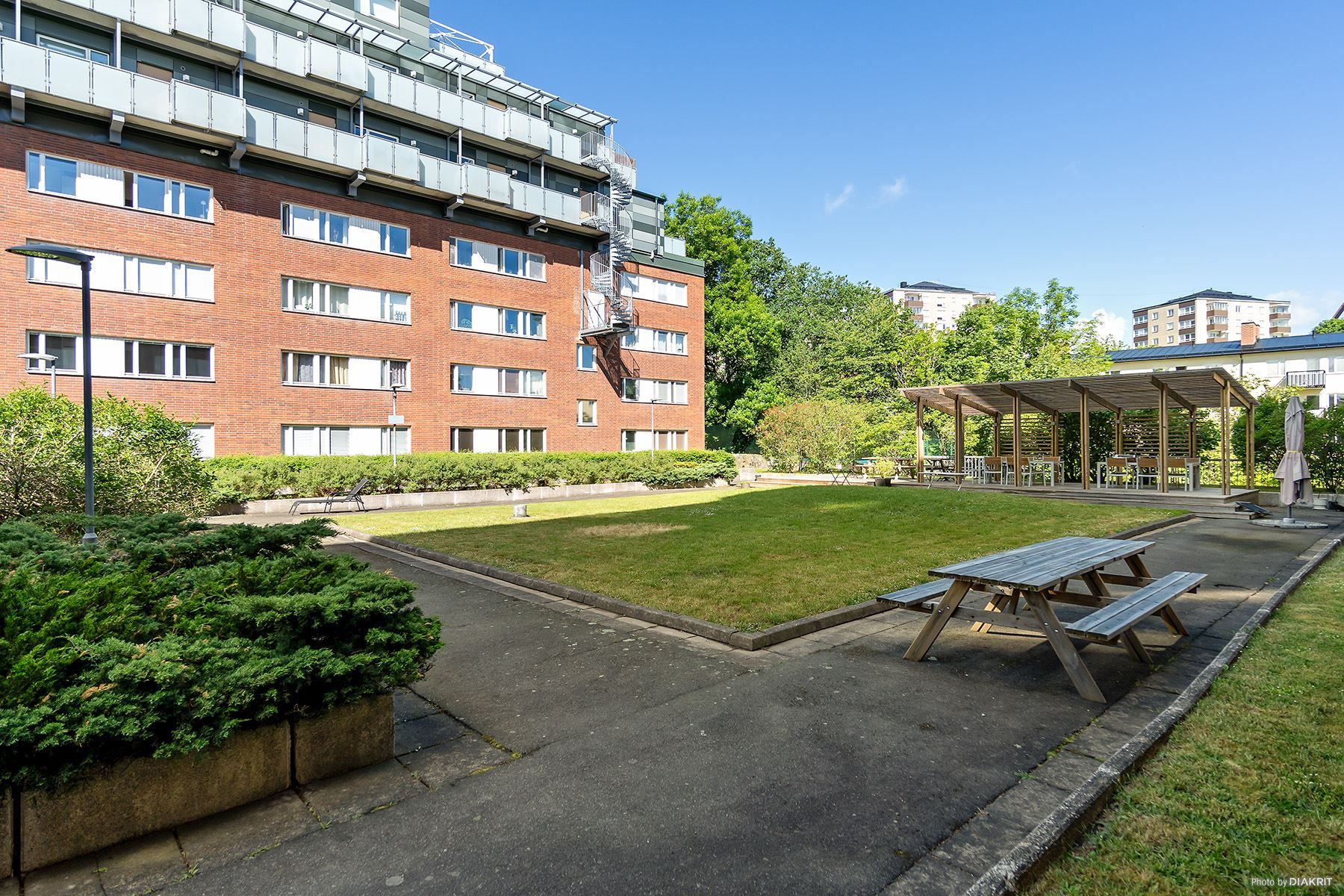 Föreningens fina innergård med pergola, grillplats, sittplatser och gräsmatta