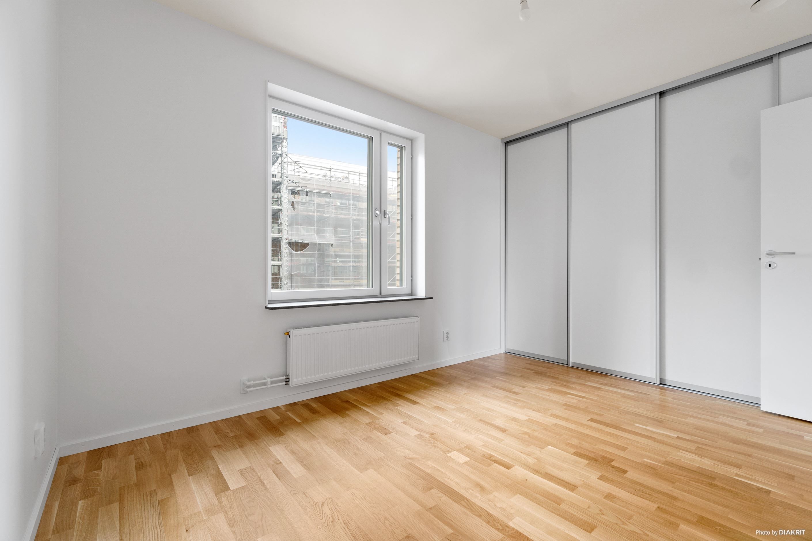 Rymligt sovrum med fönster in mot gården och gott om förvaring i skjutdörrsgarderob