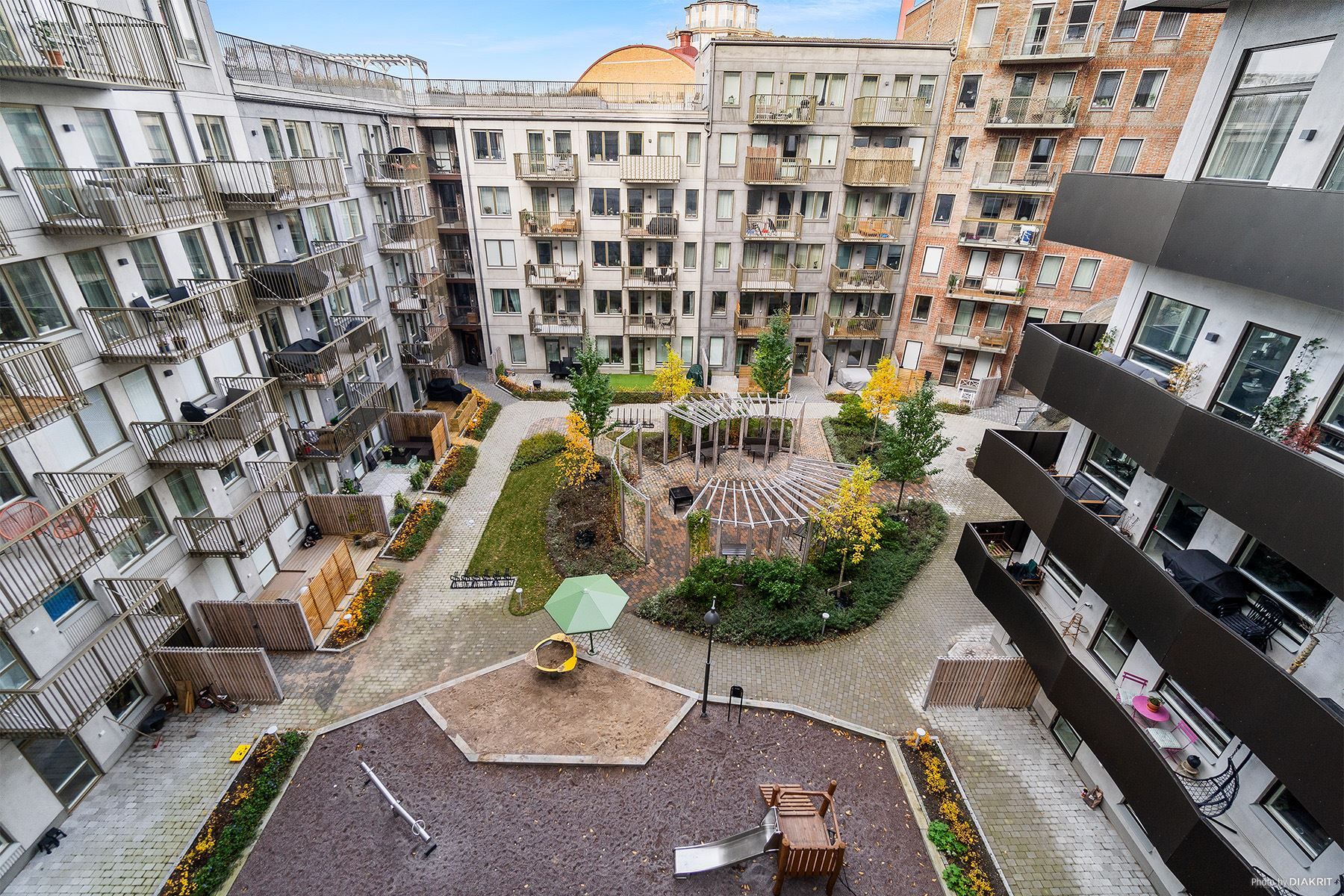 Trevlig, skyddad innergård med fina planteringar, pergola, grillplats och en lekplats
