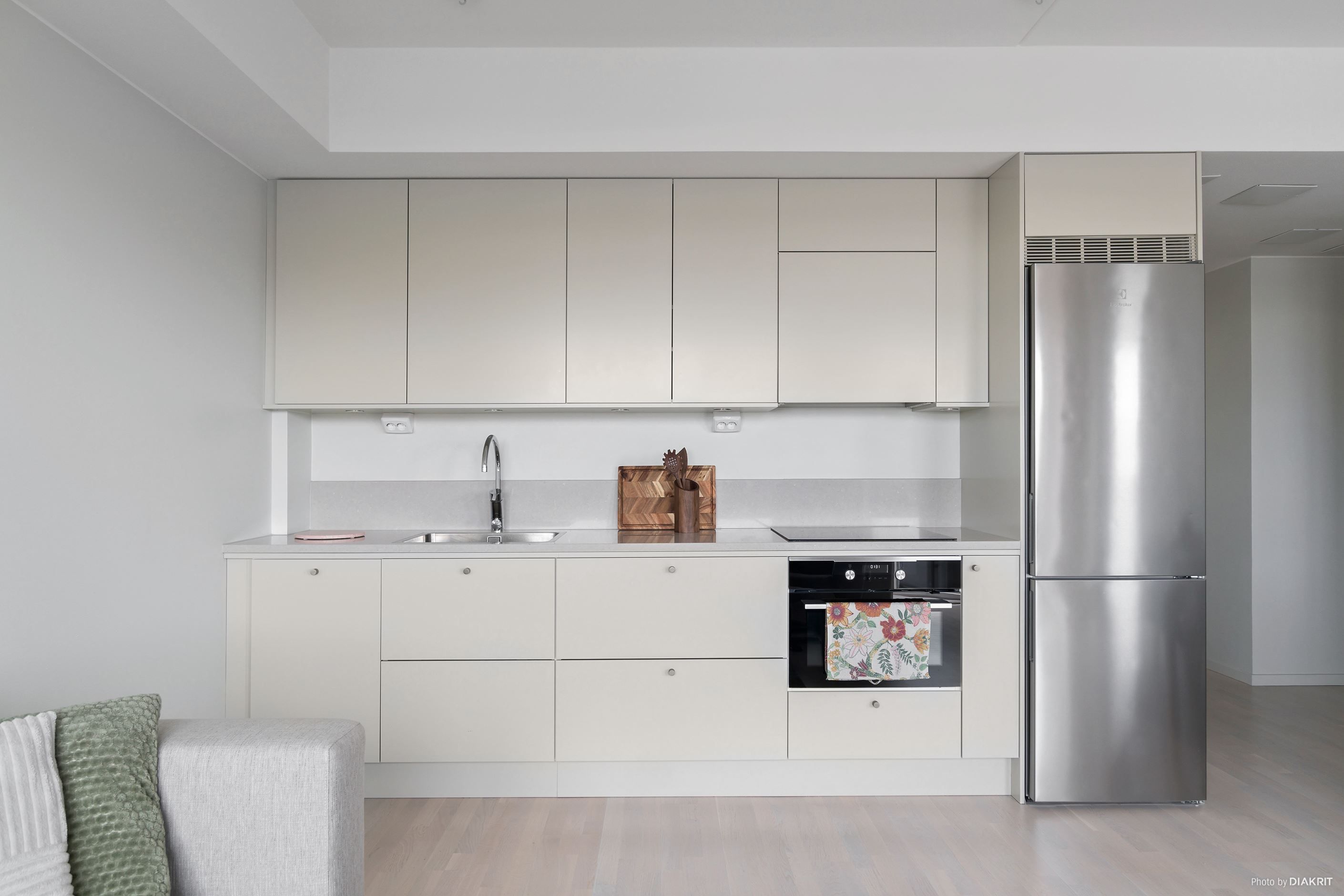 Kök från Vedum i sober ton med bänkskiva och stänkskydd i kompositsten samt vitvaror från Electrolux