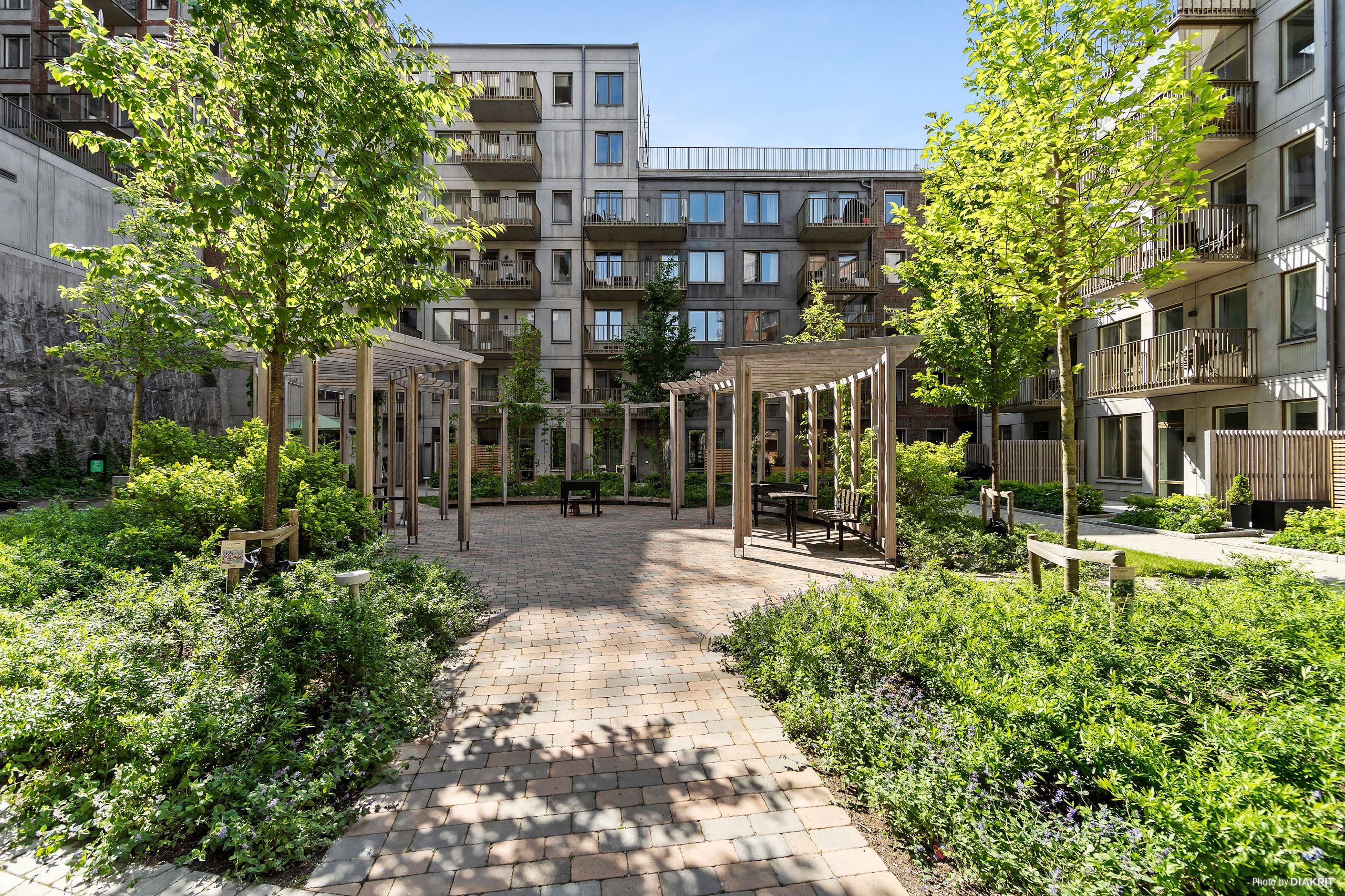 Kvarterets fina innergården med pergola, sittplatser och grill