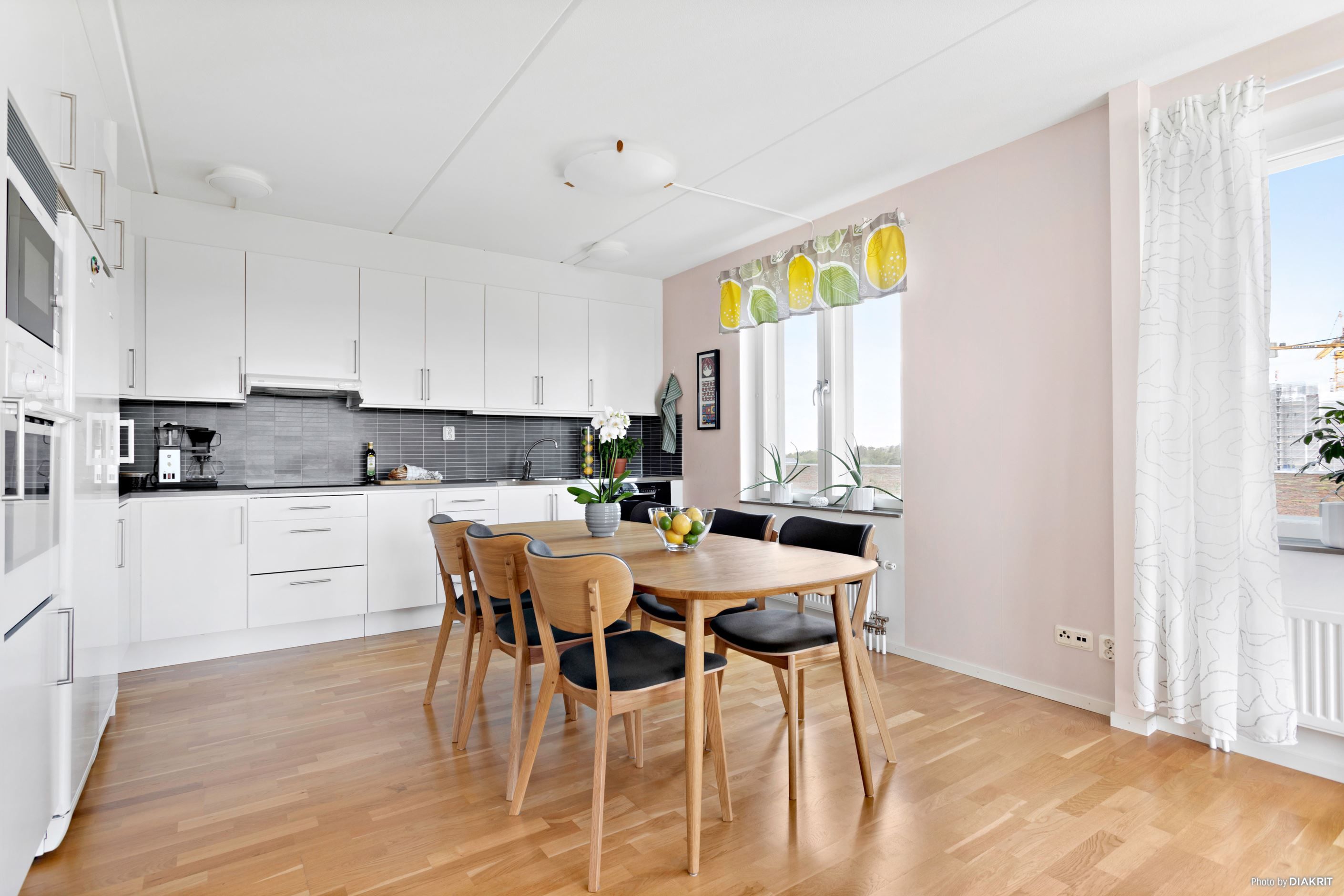 Kök med fint ljusinsläpp från flera fönster och plats för stort matbord för många middagsgäster