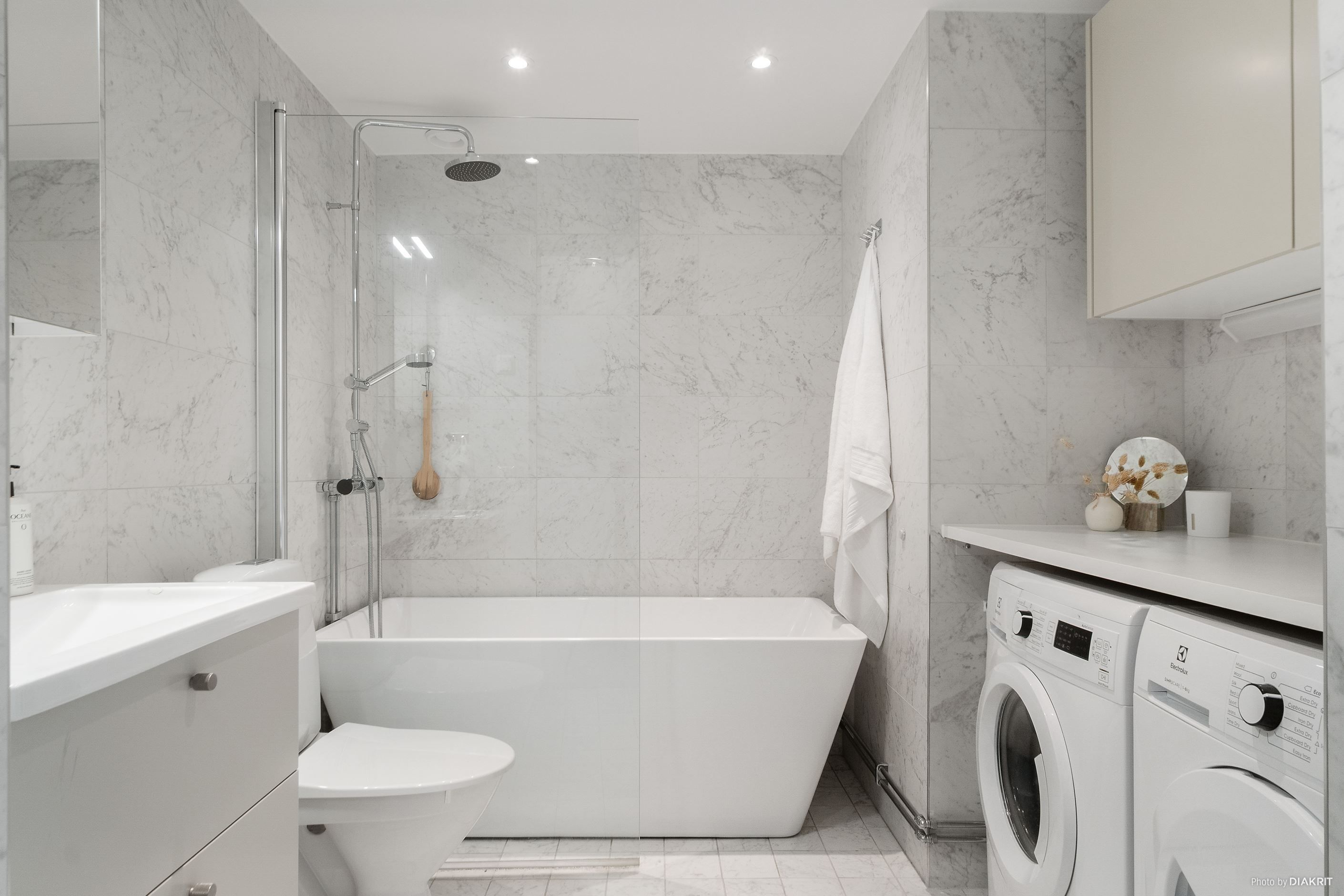 Helkaklat badrum med golvvärme, badkar samt tvättmaskin och torktumlare från Electrolux