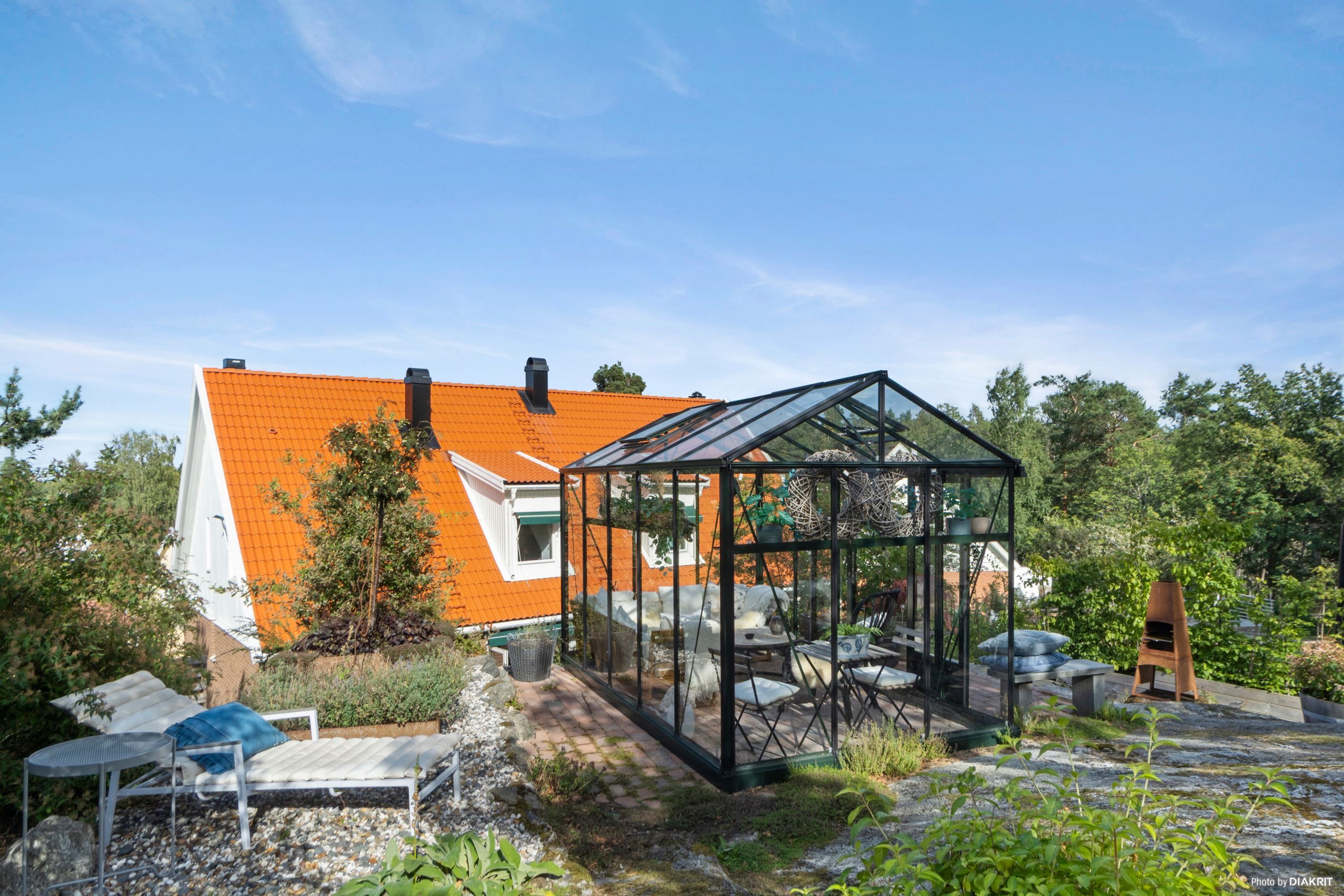 Växthus och fina ytor på övre delen av tomten, vilken angränsar till naturen.
