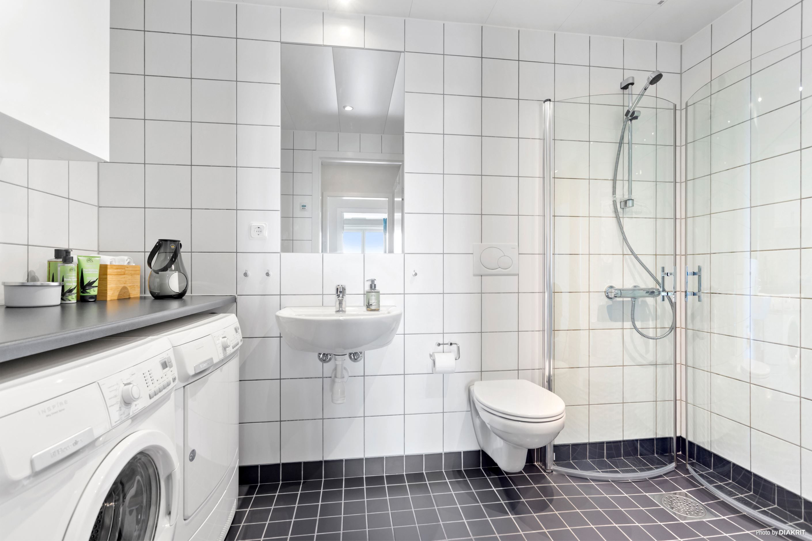 Rymligt badrum med tvättmaskin och torktumlare