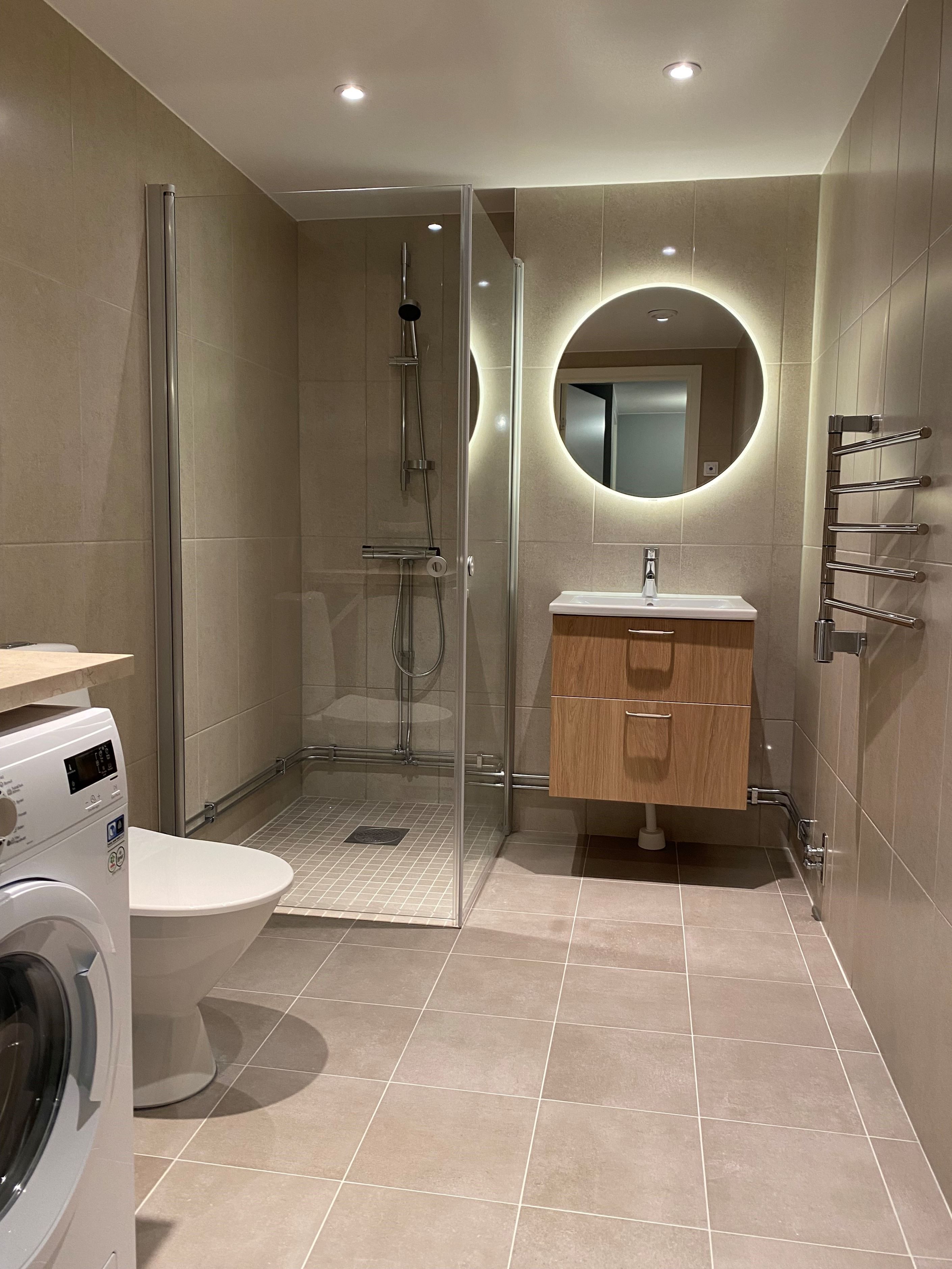 Helkaklat badrum med komfortvärme i golvet, handdukstork samt kombimaskin (tvätt/tork)