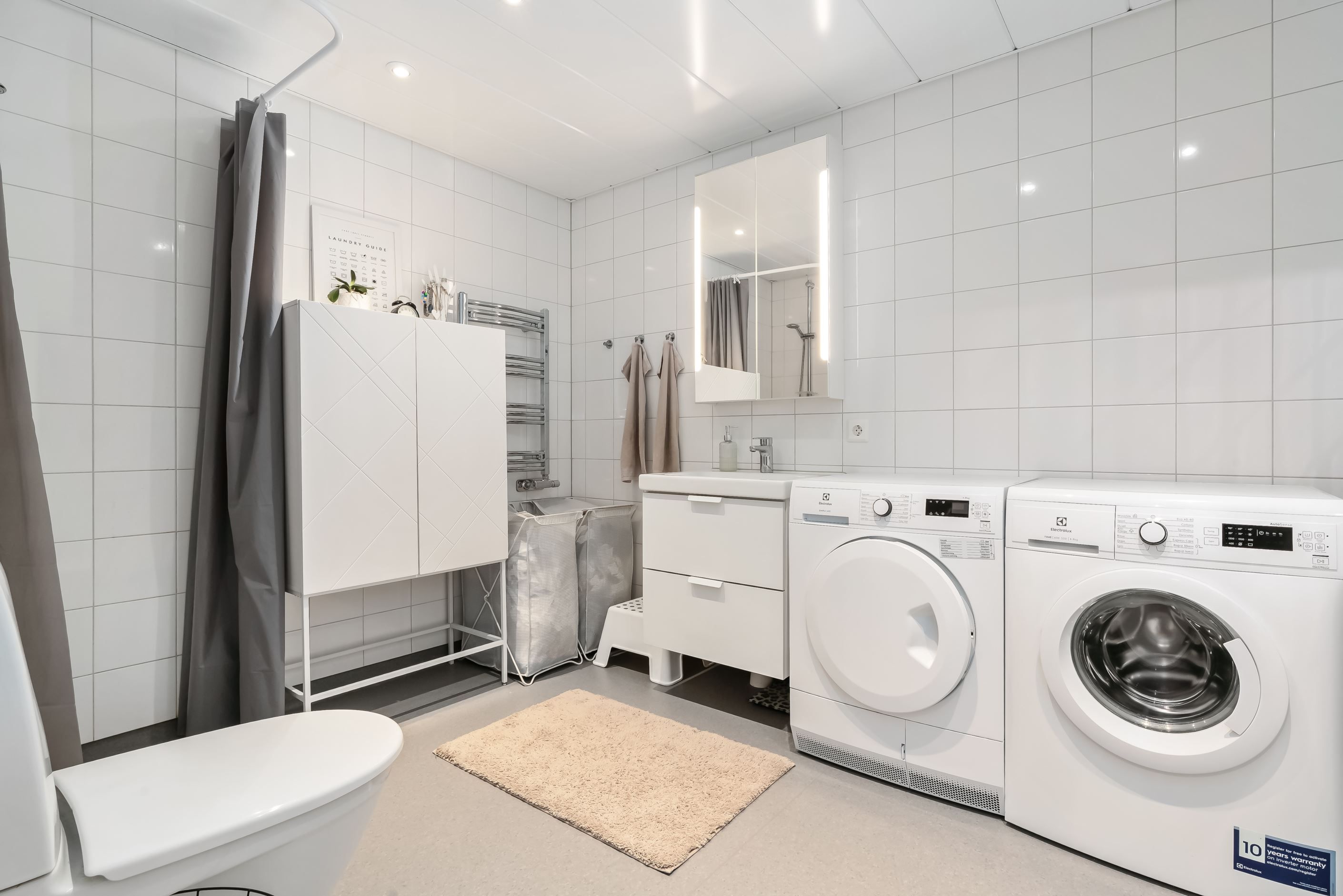 Badrum med duschhörna och tvättmaskin